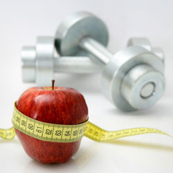 dumbbells and an apple wrapped in measuring tape